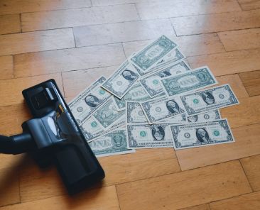 a pile of money sitting on top of a wooden floor