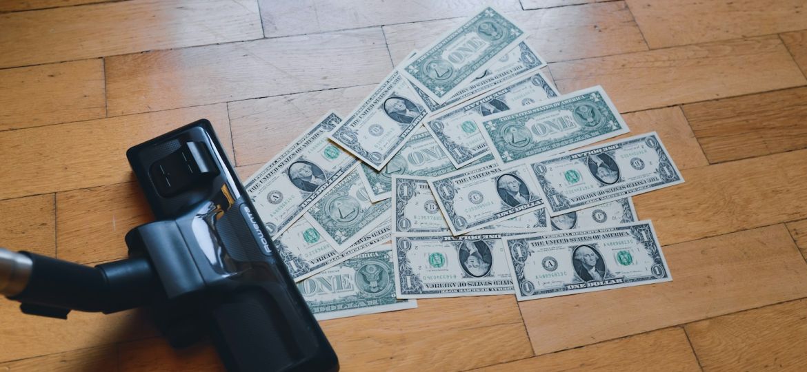 a pile of money sitting on top of a wooden floor